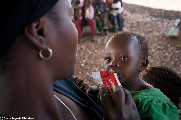 Una refugiada congoleña recién llegada le da Plumpy'Nut a su hijo a quien se le diagnosticó desnutrición después de ser examinado en el centro de recepción de refugiados en Kyangwali.