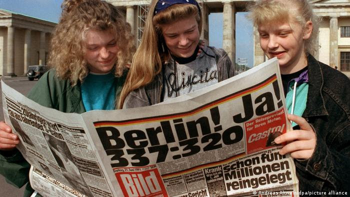 Jovens leem jornal em alemão