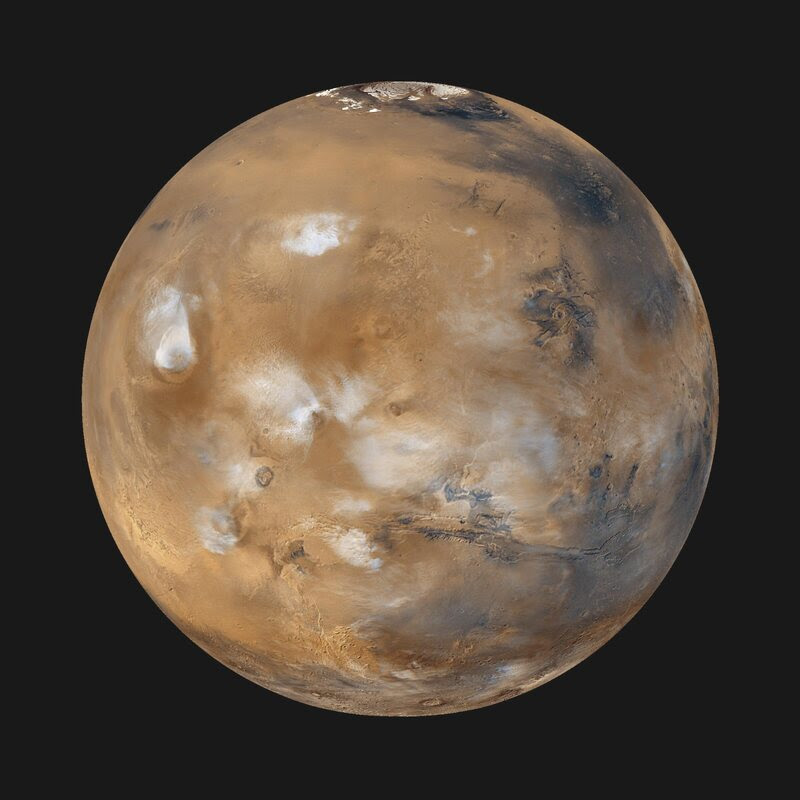 A view of Mars, showing ice clouds hanging above the Tharsis volcanoes.