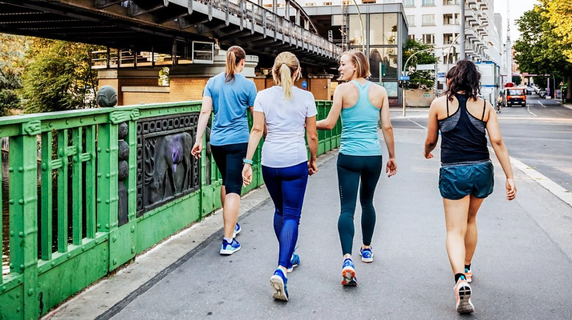 a group of friends walking together wearing workout gear