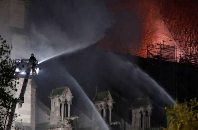Slide 7 of 31: Fire fighters douse flames of the burning Notre Dame Cathedral in Paris, France April 15, 2019. REUTERS/Charles Platiau