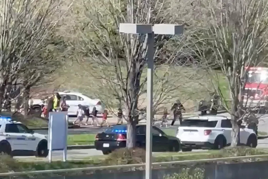 Law enforcement officers lead children away from the scene of a shooting at The Covenant School, a private Christian school in Nashville, Tenn., on Monday March, 27, 2023. (Jozen Reodica via AP)