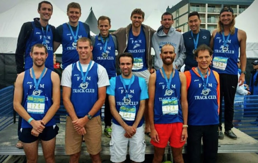A group of men with blue running singlets and medals posing for a photo.