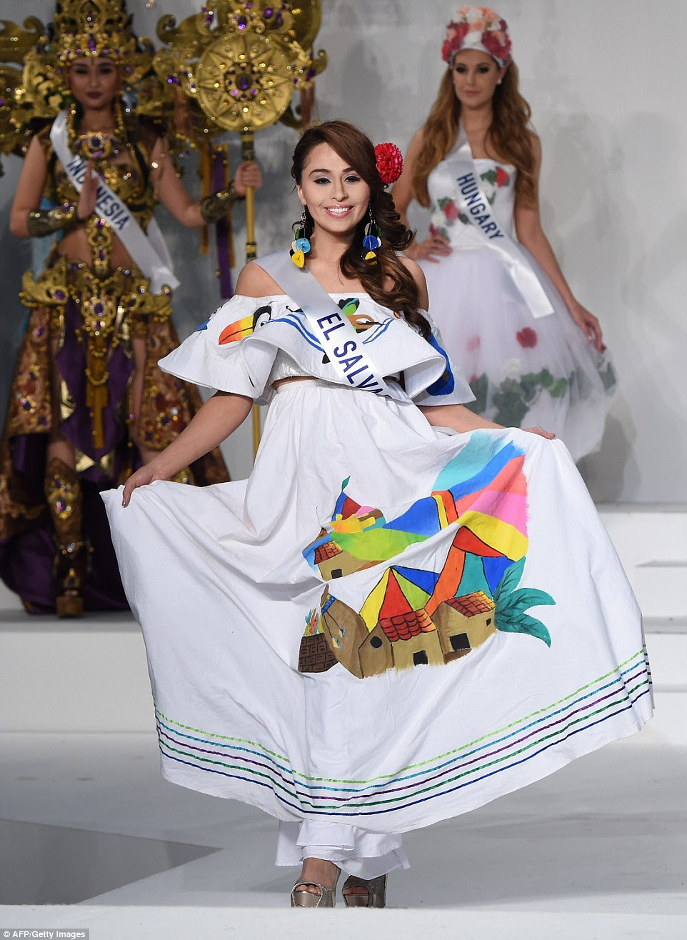 El Salvador kept things simple with Eugenia Avalos wearing a white cotton dress depicting vibrant scenes of a classic country landscape, as well as pottery and a colourful toucan
