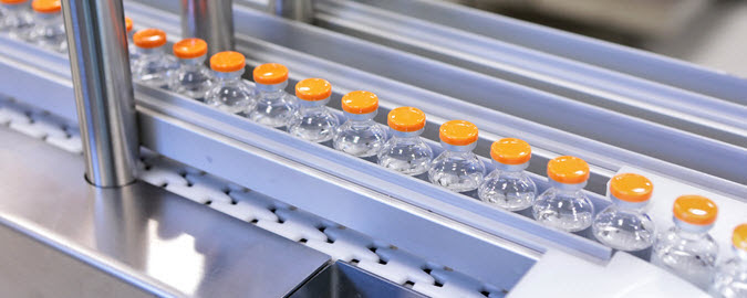 vials of vaccine on conveyor belt