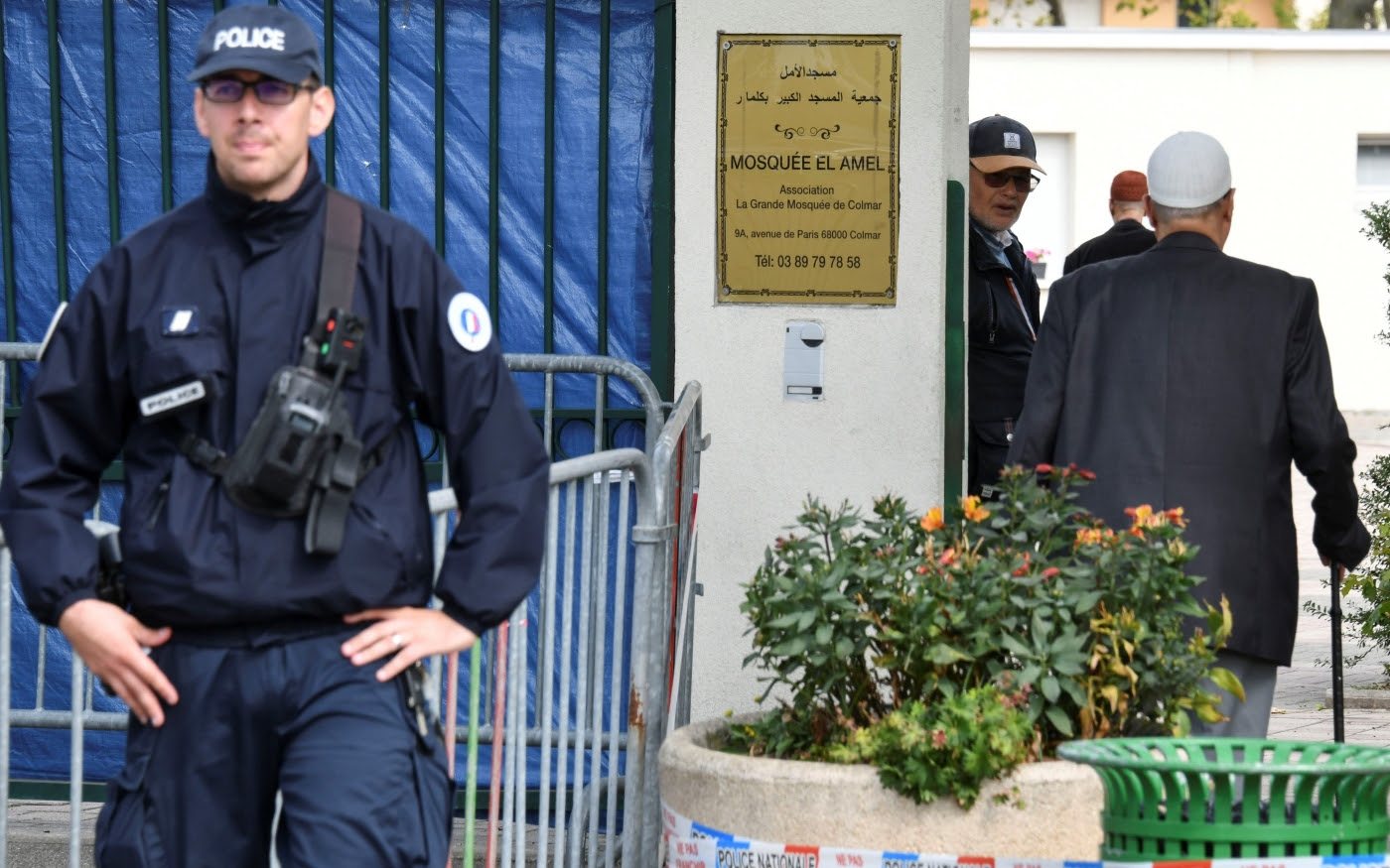 Des fidèles arrivent à la grande mosquée de Colmar, dans l’est de la France, où un policier monte la garde, le 22 septembre 2019 (AFP)