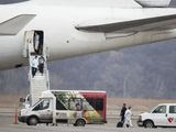 Officials help passengers off a plane to waiting vehicles at Eppley Airfield in Omaha, Neb., on Monday, Feb 17, 2020. American citizens who were on a cruise ship off Japan&#39;s coast who were at high risk of being exposed to the novel coronavirus were taken to the University of Nebraska Medical Center campus after landing. (Z Long/Omaha World-Herald via AP)