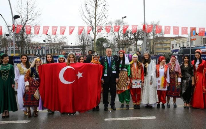 Erdogan, centre, poses for a photos with the members of a folklore group as he arrives to address his supporters in Sakarya, Turkey on Thursday