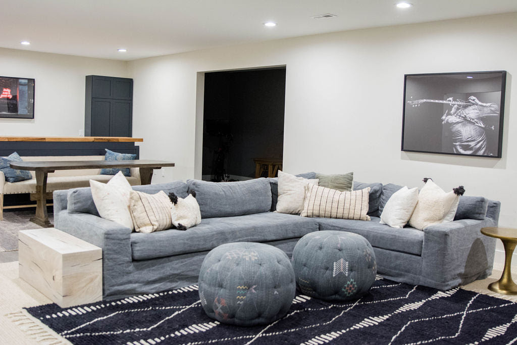 This basement features a Cisco Brothers Loft Slipcovered Sectional with black Moroccan Tulum Rug -- mixing indigo and navy and black for a masculine basement reveal!