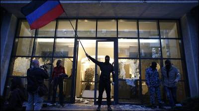 Un miliciano prorruso ondea una bandera de Donbass tras tomar un edificio oficial en esta ciudad oriental de Ucrania.