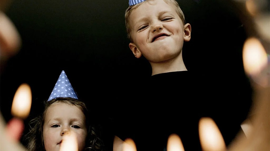 a child with adhd is blowing out the candles on his birthday cake