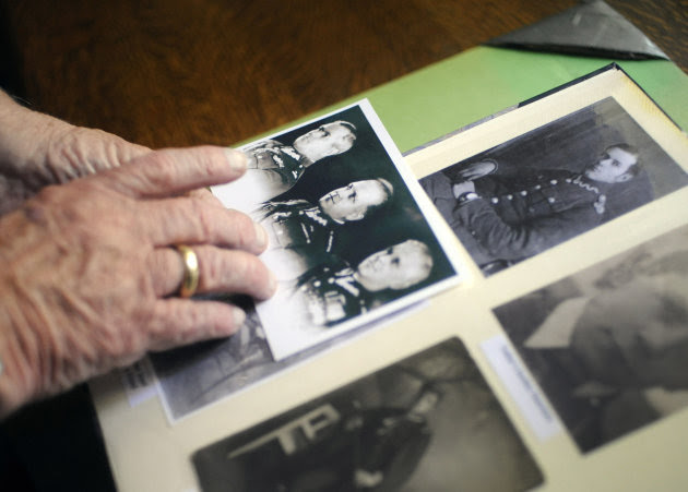 In this Friday, Sept. 7, 2012 photo, Franciszek Herzog looks at photographs of his father at his home in Hebron, Conn. Documents released Monday, Sept. 10, 2012, and seen in advance by The Associated Press lend further weight to the belief that sabotage within the highest levels of U.S. government helped cover up Soviet guilt in the killing of some 22,000 Polish officers and other prisoners in the Katyn Forest and other locations in 1940. Herzog's father and uncle both died in the massacres. (AP Photo/Jessica Hill)