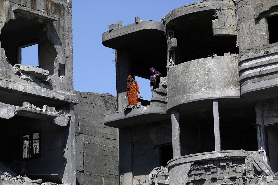 Palestinian women inspect the damage to their home in Jabaliya in the northern Gaza Strip