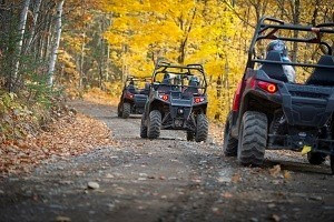 ORVs on wooded trail with fall foliage