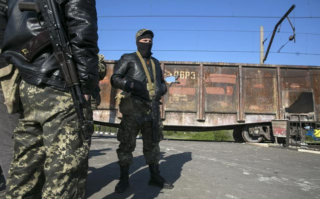 Prorrusos armados vigilan un puesto de control junto a una vía de tren en Slaviansk.