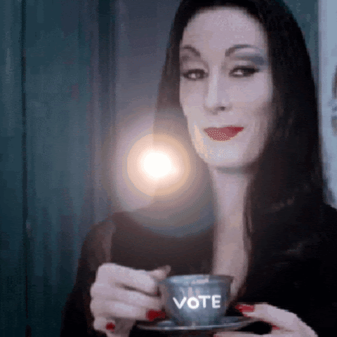 Image of a witch drinking tea and the glass says "vote"