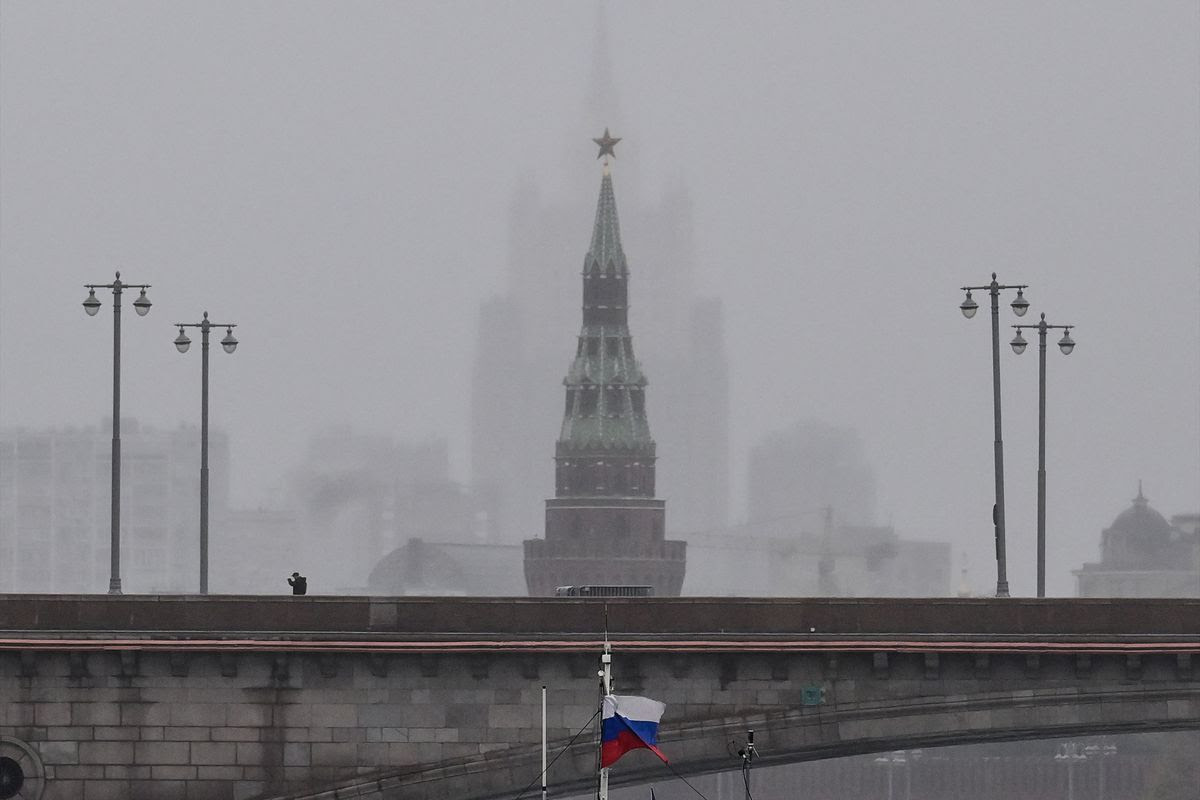 A pedestrian walks along a bridge over the Moskva River in front of the Vodovzvodnaya tower of the Kremlin and the Russian Foreign Ministry headquarters in central Moscow on October 4, 2022.
