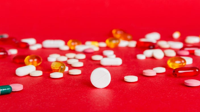 Colorful pills on a red background.