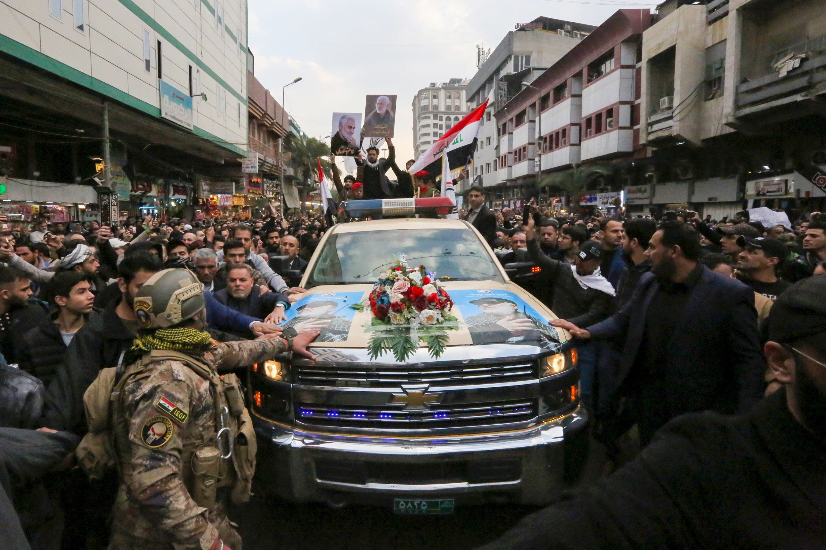  Mourners surround a car carrying the coffin of Iranian military commander Qasem Soleimani