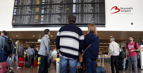 Pasajeros contemplan un panel de información de vuelos en el aeropuerto de Zaventem, cerca de Bruselas. - REUTERS