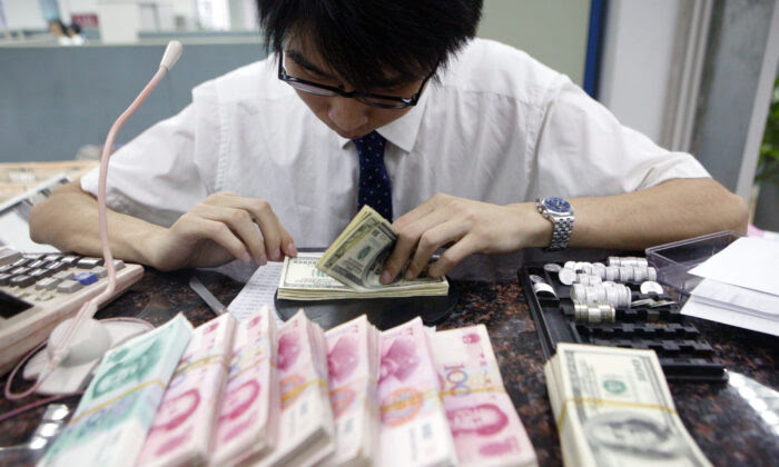 A clerk counts stacks of Chinese yuan and U.S. dollars at a bank in Shanghai, China, on July 22, 2005. (China Photos/Getty Images)