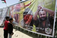 Arab children look at pictures of two of a kind - Arafat and Barghouti.