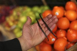 A man holds whole vanilla beans at a grocery market in San Francisco, California