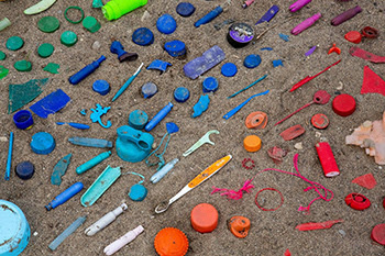 Colorful plastic items found in a beach trash pickup are sorted.