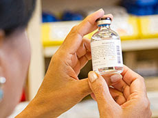 pharmacist examining drug vial