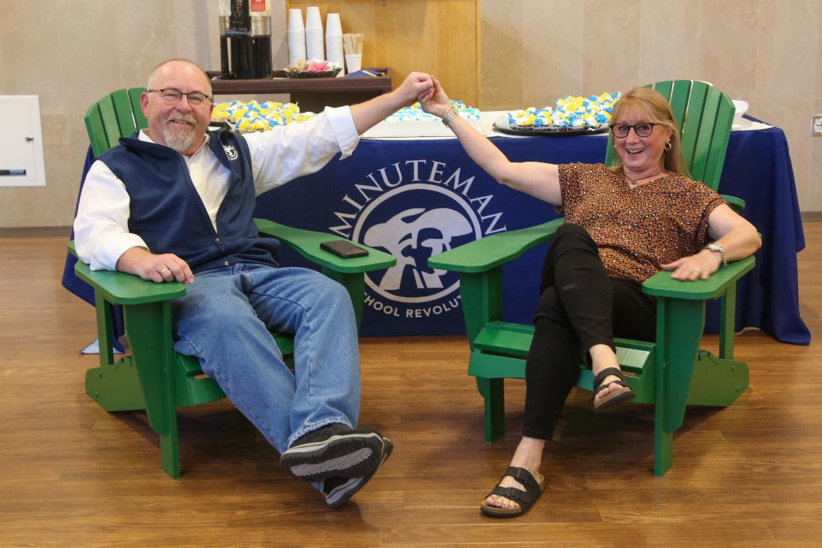 Dr. Ed Bouquillon and his wife, Diana, in Adirondack chairs that were gifted to them from students in the Carpentry program at his retirement celebration on May 12, (Photo by Reba Saldanha)