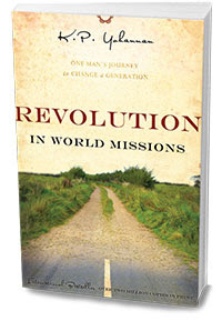 Revolution in Missions -Book Cover shows a dusty road with sparse vegetation and a few trees at the sides. The name of the author, K. P. Yohannan is in handwriting at the top.