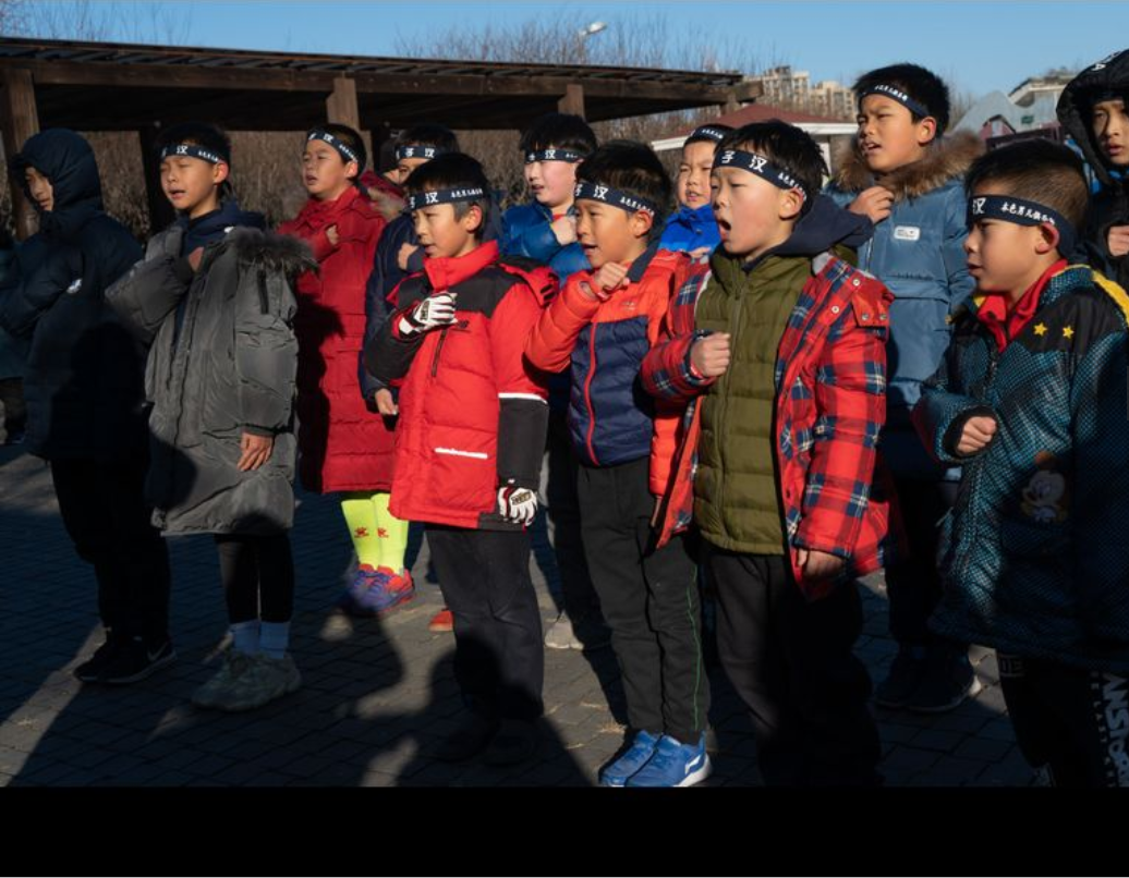Các bé trai người Trung Quốc đọc lời cam kết trước khi thực hiện các hoạt động nhóm. (Ảnh: Yan Cong / For The Times)