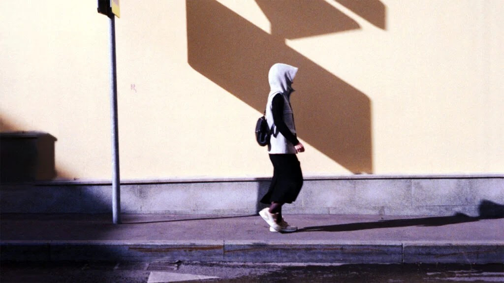 image of person in tracksuit walking down the road