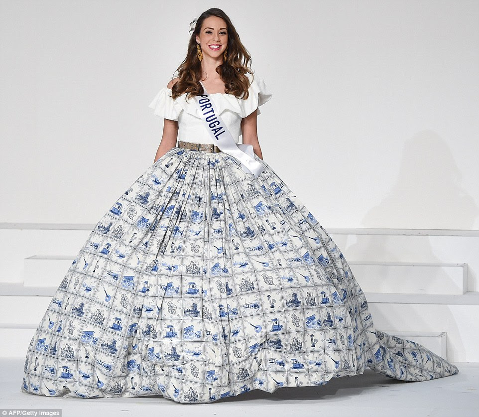 Portugal's instantly recognisable blue-and-white tiles formed the basis of Miss Portugal's skirt pattern. The full skirt, held out by a crinoline petticoat, depicts traditional houses, instruments and scenes in the tiled design. Isabel Vieira teamed the skirt with an off-the-shoulder top with ruffled edging and a grey waist belt