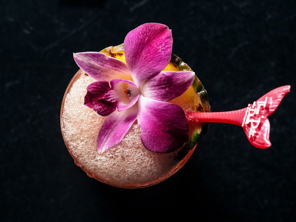 A cocktail with a pink flower