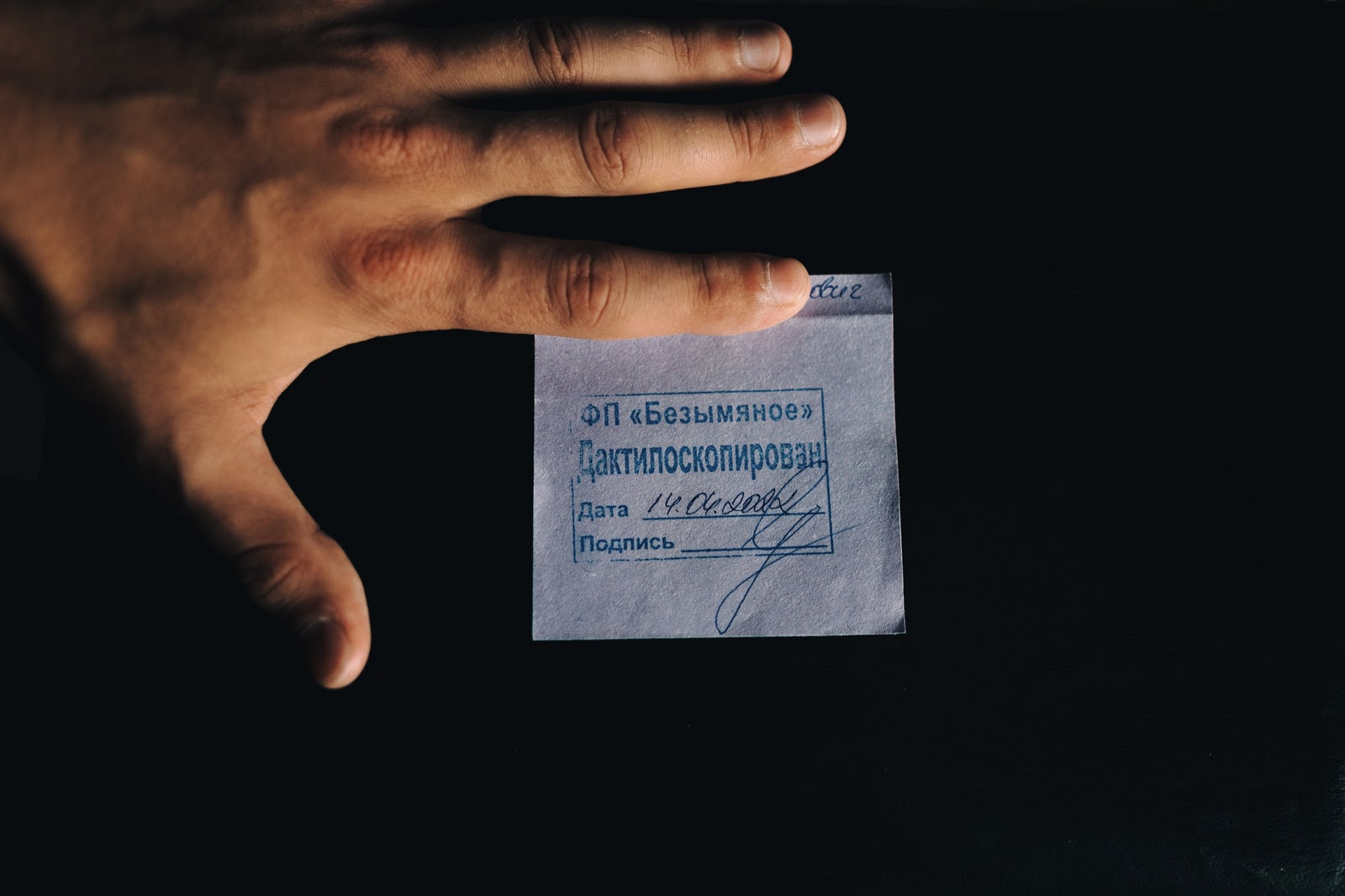 A hand touches a paper filtration receipt issued to a Ukranian citizen.