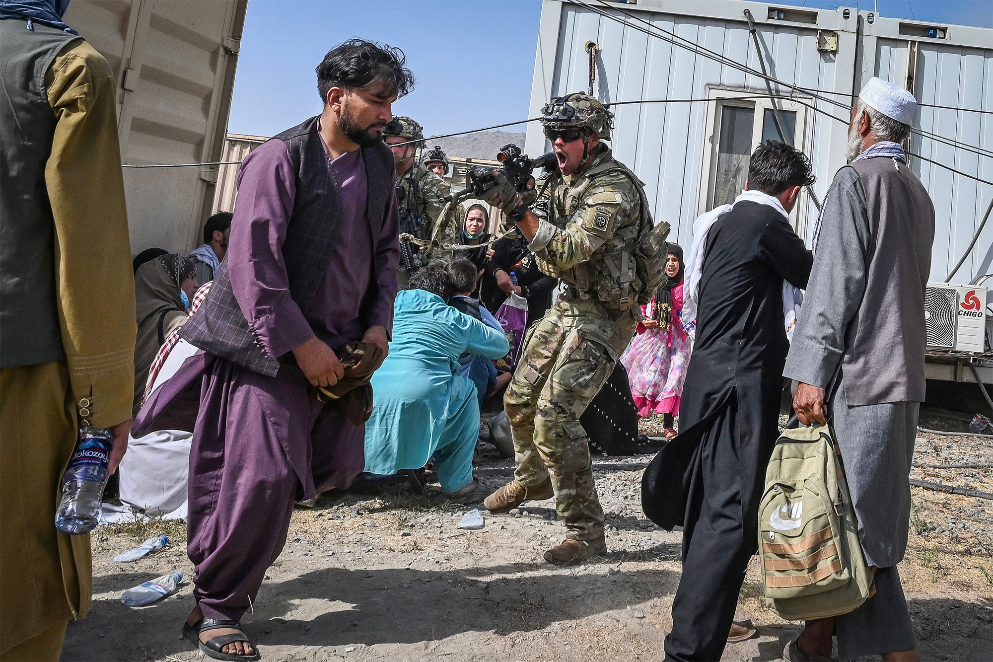 A US soldier points his gun towards an Afghan passenger at the Kabul airport.