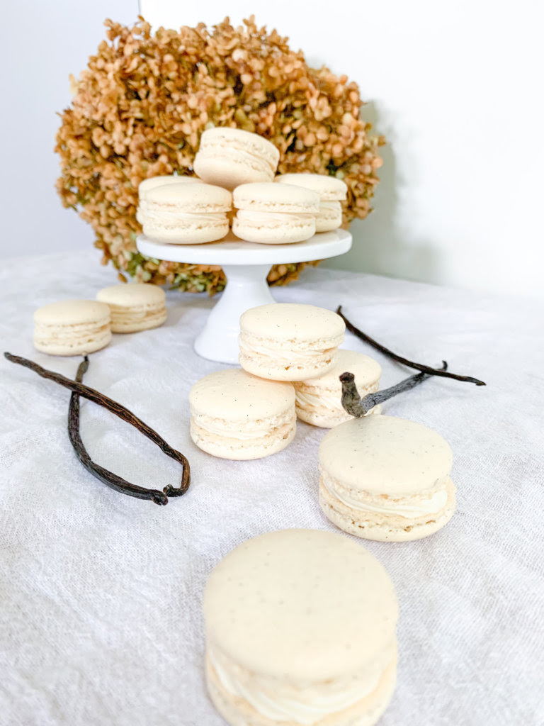 macarons on a pedestal with a hydrangea behind
