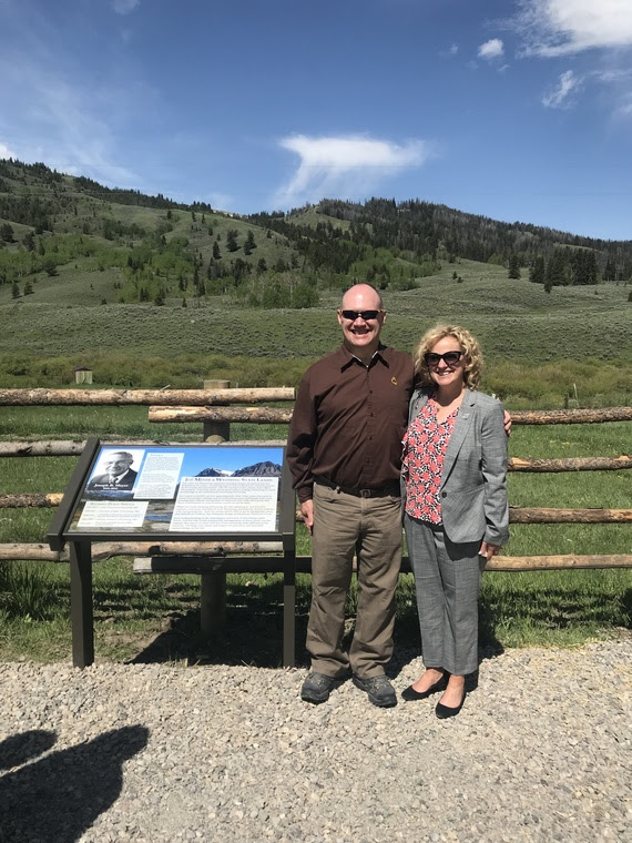 Superintendent Balow stands with Vince Meyer next to the sign that explains the dedication of the land behind them to Joe Meyer.