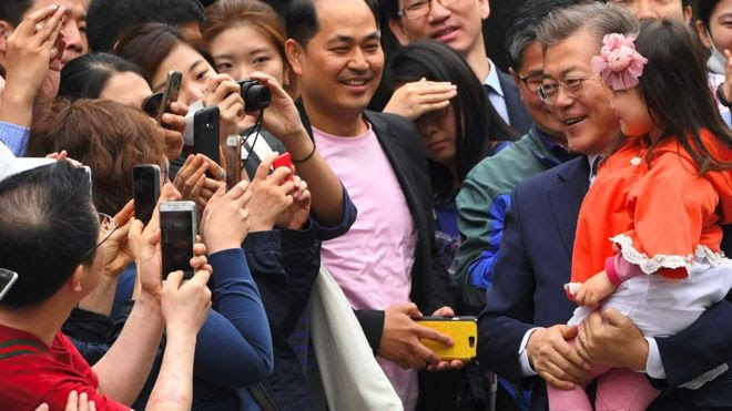 Ông Moon Jae-in bế cháu khi tiếp xúc cử tri lúc tranh cử tổng thống Hàn Quốc