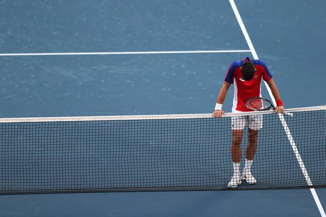 Novak Djokovic hangs his head at the net 