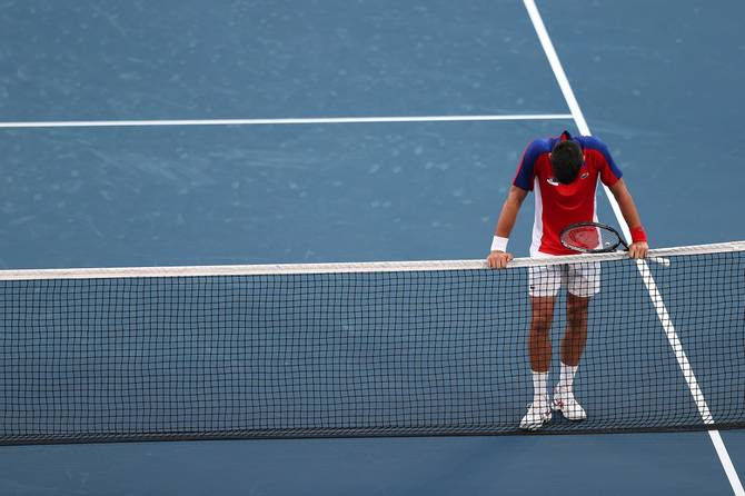Novak Djokovic hangs his head at the net