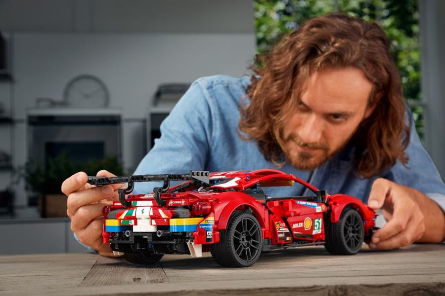Image of a man looking at the LEGO model sitting on a table
