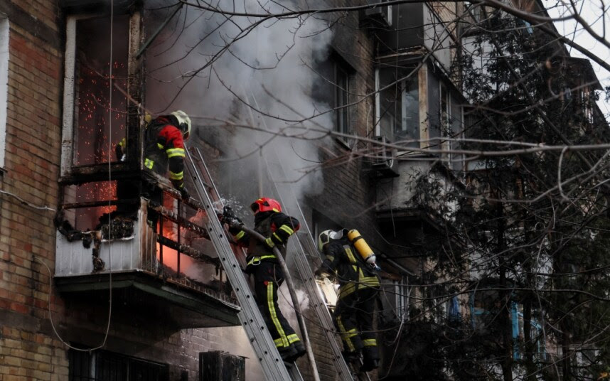 Firefighters work to put out a blaze on a burning block in Kyiv