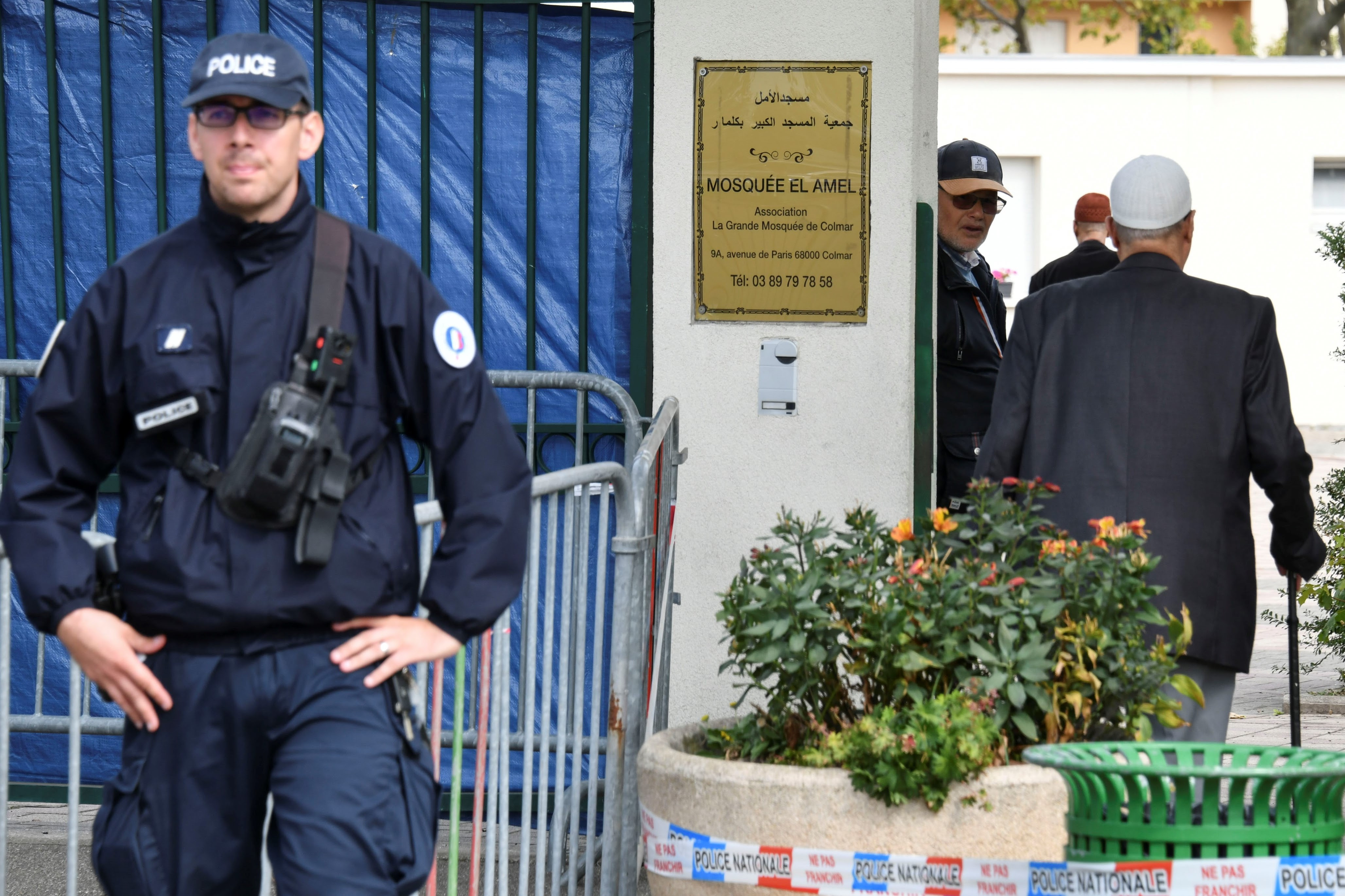 Worshippers arrive at the Grande Mosque in Colmar, eastern France, while a police officer stands guard on 22 September (AFP