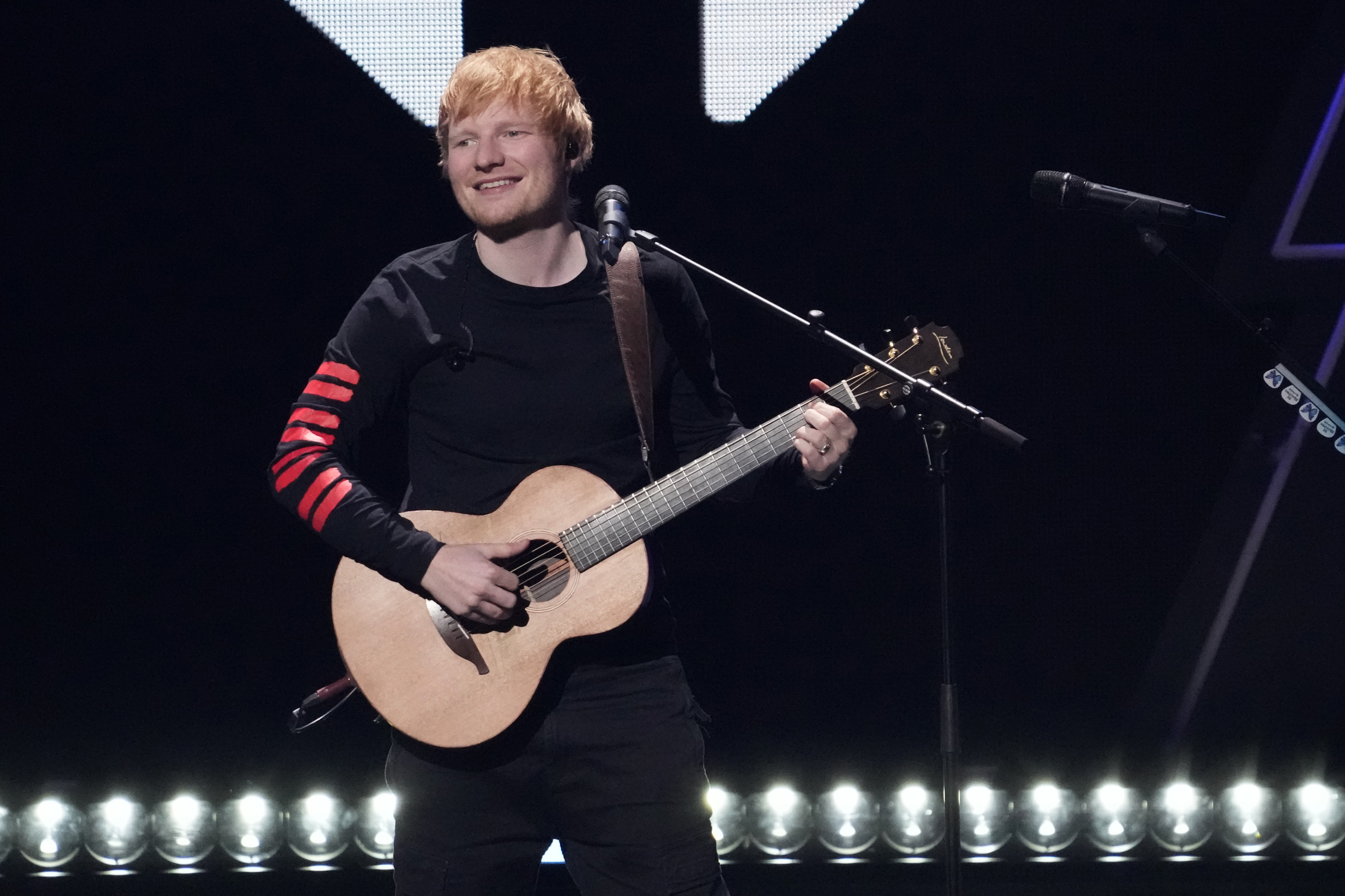 This image shows Ed Sheeran performing at a concert