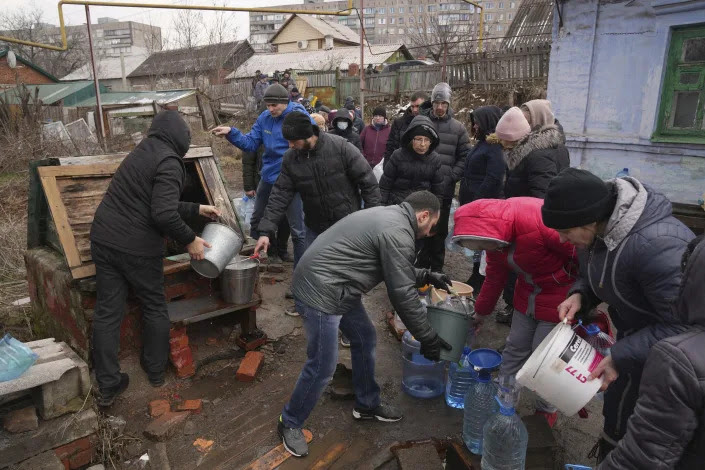 People line up to get water at the well in outskirts of Mariupol.