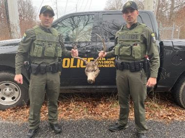 two officers holding mule deer head