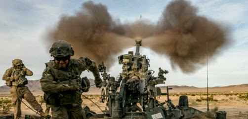 Army Spc. Eric Hayden fires an M777A2 howitzer while Staff Sgt. Robert Hartner braces to handle the shock of firing at the National Training Center at Fort Irwin, Calif., March 5th, 2020. - ALLOW IMAGES
