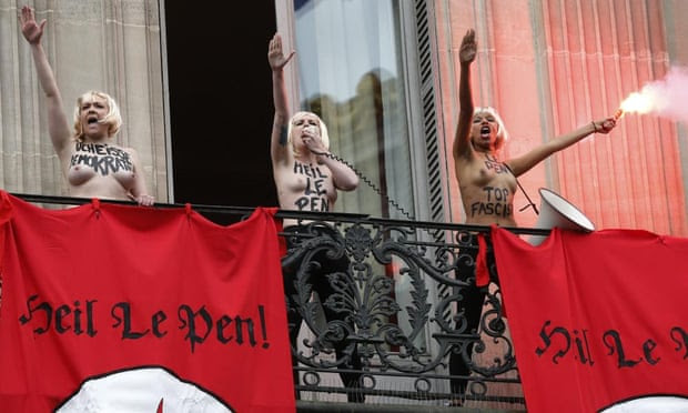 Topless Femen activists perform the Nazi salute as they demonstrate on a balcony against France’s far-right Front National.